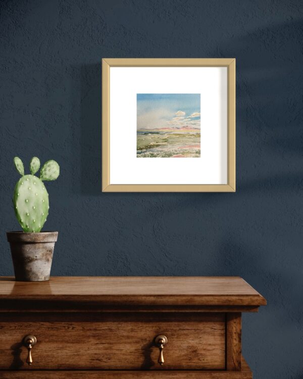 A framed watercolor painting by Lindsey Kiser of an oasis in the desert.