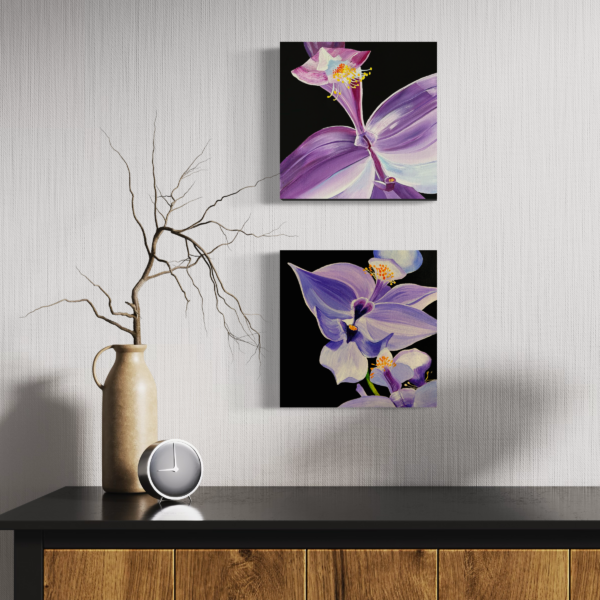 Two paintings of purple orchids on black backgrounds shown on a wall styled with interior decorating.