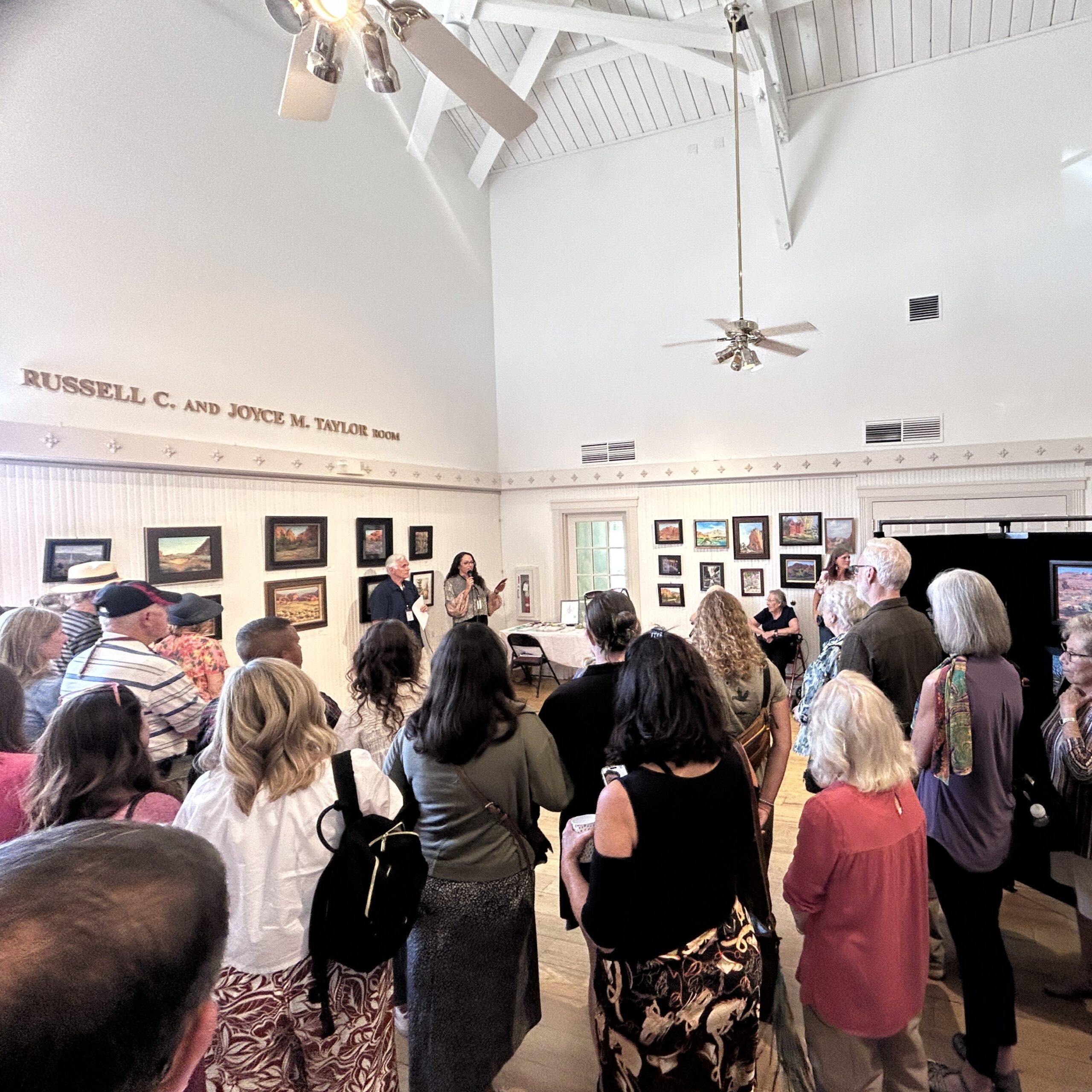 Image of a crowd of artists and collectors at the awards reception for the St George Plein Air Art Festival in St. George, Utah where Scratchboard Artist Lindsey Kiser was awarded first place for her 2' x 3" miniature scratchboard of Ash Down Gorge.